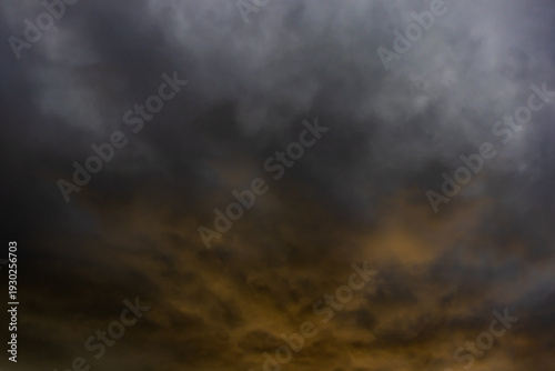 Golden light breaking through heavy storm clouds