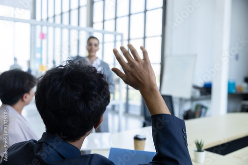 Tableau sur toile Business professional raising hand during corporate meeting in modern office, ac