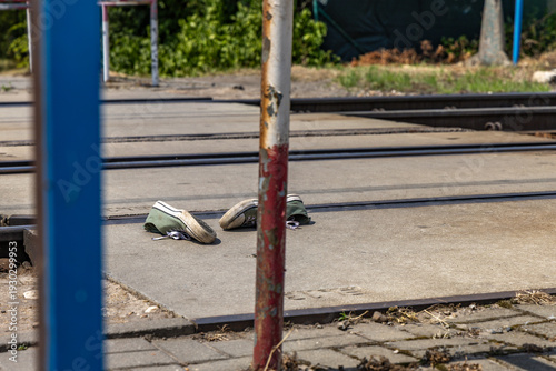 Old tennis shoes lying on a railway crossing, crime scene, mental health crisis of young people