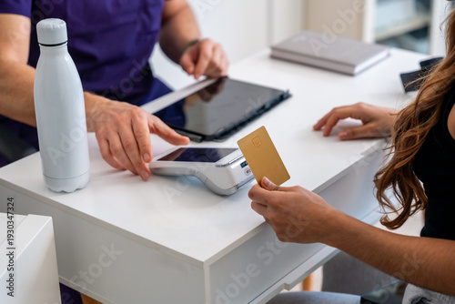 Quadro su tela Patient paying for medical physiotherapy treatment using credit card