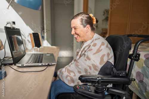 Woman smiling using assistive technology laptop for online communication