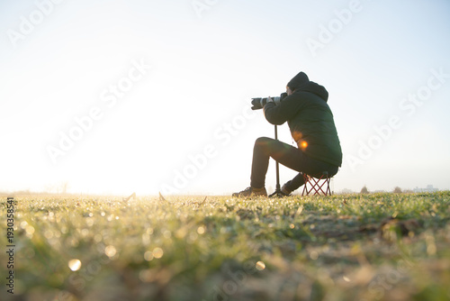 朝焼けの中、写真を撮る男性