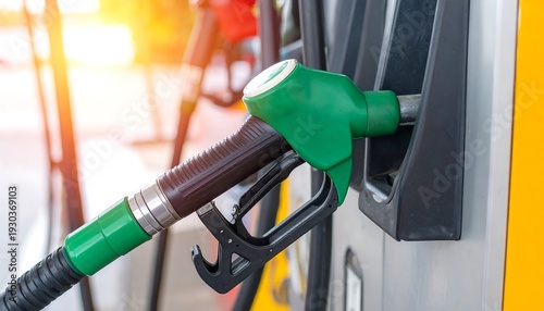 Close-up of a green gasoline pump nozzle at a gas station.