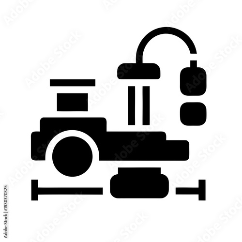 A black and white icon of a dental chair and tools