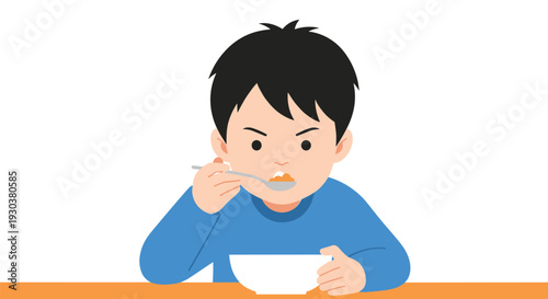 Young boy sitting at a table and eating a meal with a spoon from a white bowl with a focused and determined expression.