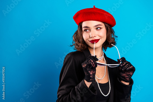 Fotografía Glamorous young woman in red beret posing with sunglass and pearls against a blu