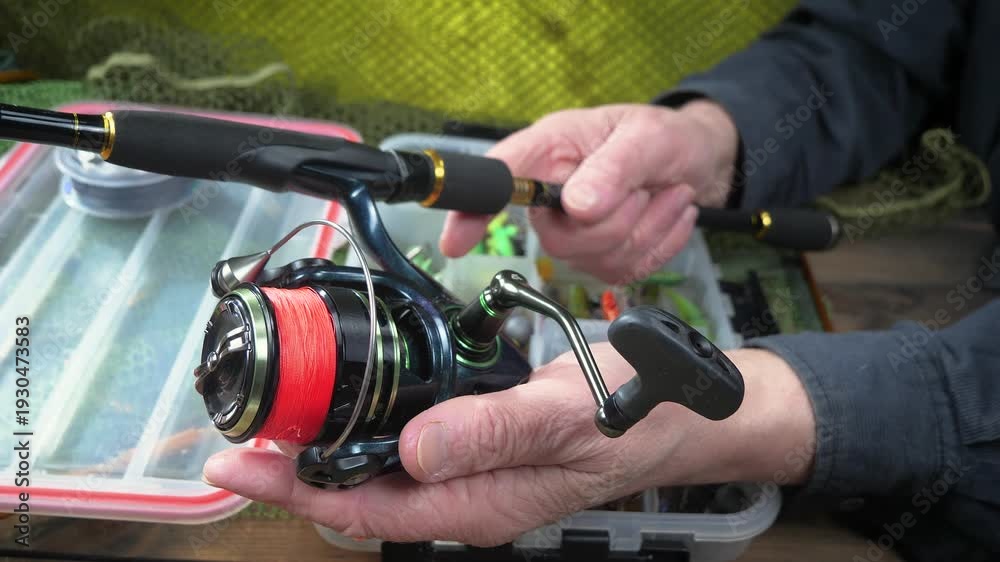 custom made wallpaper toronto digitalSport fishing equipment on a table in a studio composition, against a background of a net. A fisherman's hands check the tackle for use.