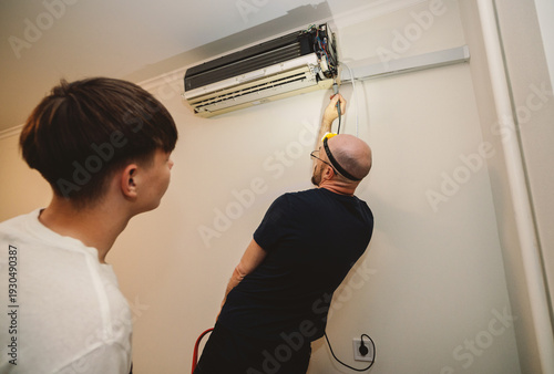 Εκτύπωση καμβά Professional HVAC Technician Repairing Indoor Air Conditioner Unit While Trainee