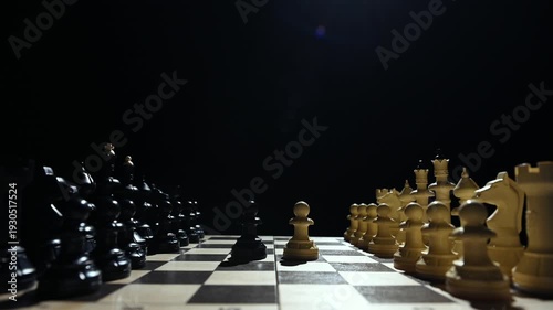 Chess pieces are facing each other on a black background. A close-up of a hand moving a white pawn 4 к