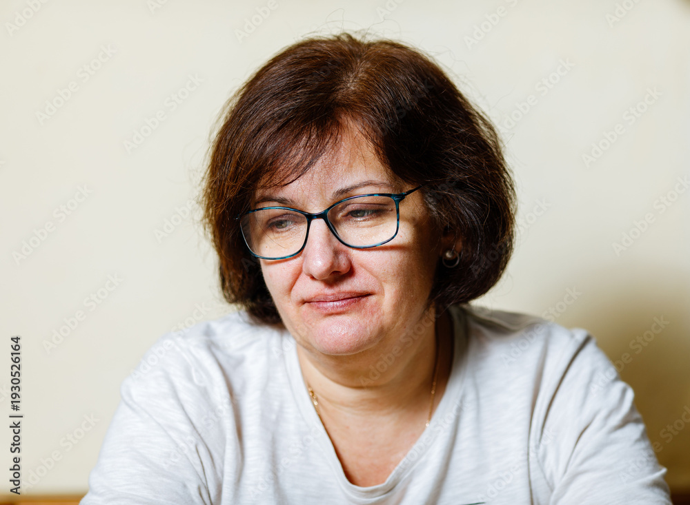 Fototapeta premium Caucasian mature female with glasses in thoughtful pose