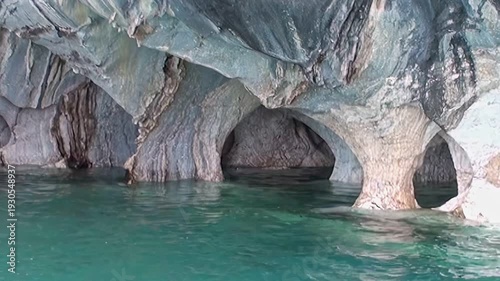 Witness the breathtaking beauty of the Marble Caves in Patagonia. Azure waters gently lap against intricately sculpted marble walls, forming stunning arches. A serene natural wonder.