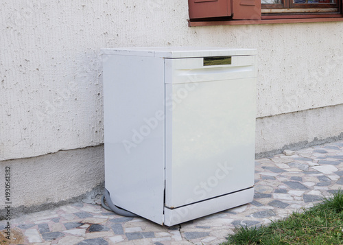Old used white dishwasher. Electronic waste. old kitchen appliance. Destroying the environment. Unnecessary waste