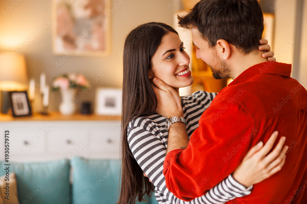 Naklejka premium Couple hugging, kissing and dancing while relaxing at home