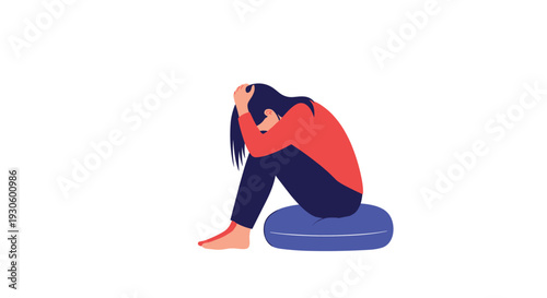A woman sits curled up on a blue cushion with her head in her hands, depicting feelings of sadness, depression, anxiety, or grief.