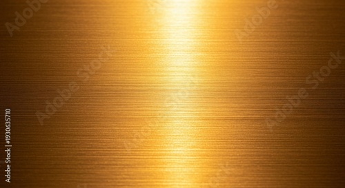 Golden metallic surface with brushed texture and bright reflection.