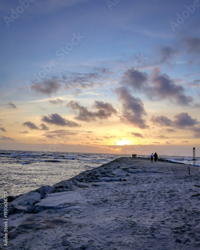 People Walking on Pier at Sunset