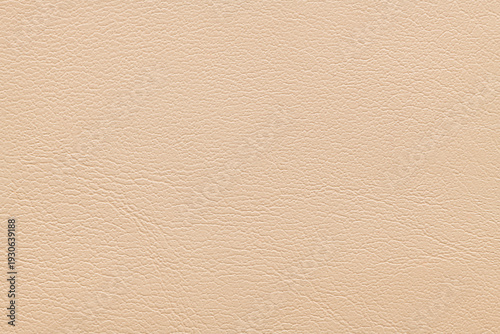 A full-frame top-down view of a light beige faux leather material showing a fine grained texture with subtle wrinkles and a matte finish suitable for upholstery or fashion backgrounds