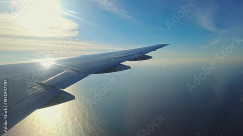 Beautiful view of airplane wing flying over Caribbean Sea at sunset. Aruba.