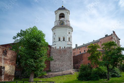 Fotografie An ancient clock tower near a ruined cathedral