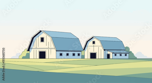 Two rural barns stand in a field with a soft sky backdrop