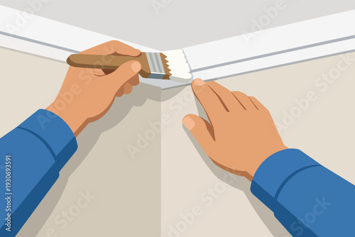 Hands painting white baseboard trim along a wall corner, home renovation