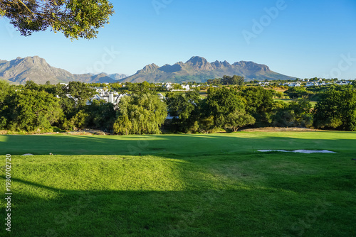 Photos South Africa,Winery in Stellenbosch ,A serene golf course with lush green fairways, trees, and distant mountains under a clear blue sky