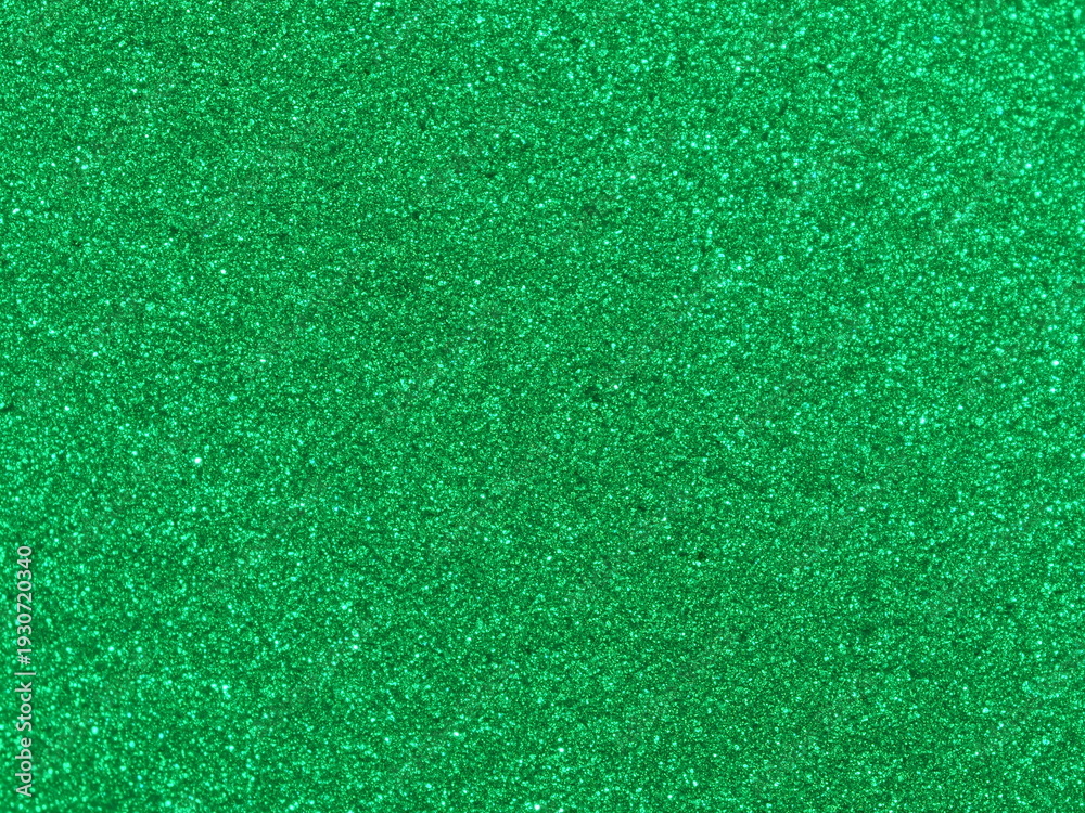 Fototapeta premium Macro photography of vibrant green metallic paint texture with fine sparkles