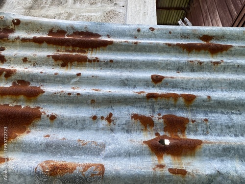 Texture of old rusty corrugated metal sheet, weathered zinc wall with brown rust stains, industrial vintage background
