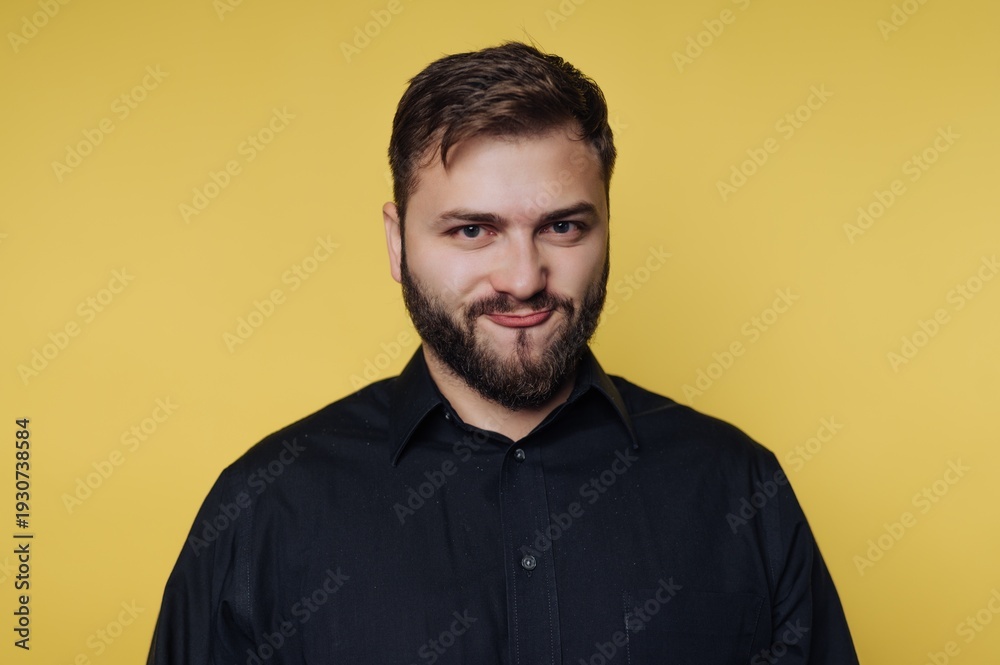 Obraz premium Portrait of a confident young man against a vibrant yellow background, showcasing personality and charm in a modern setting