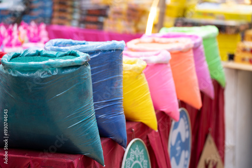 Foto Vibrant packets of colored gulal powder displayed at a market stall for the Indian festival of colors Holi, symbolizing celebration, joy, and traditional spring festivities