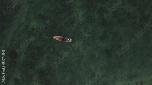 Drone footage of paddleboarder floating on clear blue ocean water near tropical coast of Sri Lanka