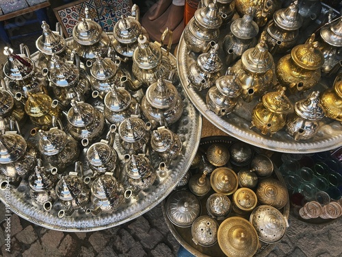 Handcraft silver oriental teapots to drink traditional moroccan tea, made of steel and popular tourist art souvenir at local street souk market (bazaar) in arabic medina of Marrakech, Morocco, Africa.