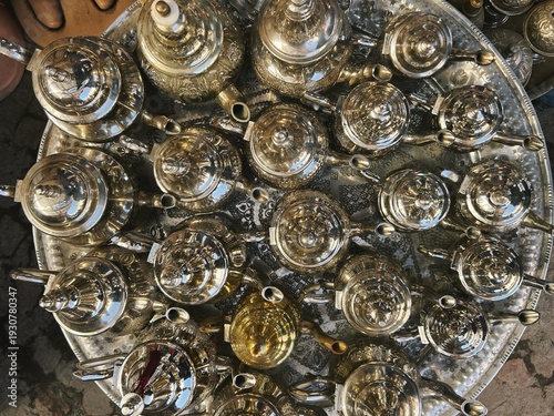Handcraft silver oriental teapots to drink traditional moroccan tea, made of steel and popular tourist art souvenir at local street souk market (bazaar) in arabic medina of Marrakech, Morocco, Africa.