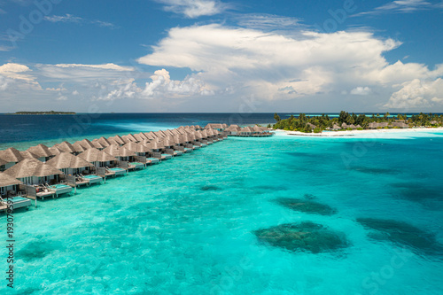 Aerial view of Maldives water villas on tropical island paradise for luxury vacation landscape background featuring turquoise lagoon and majestic resort architecture in Indian Ocean atoll