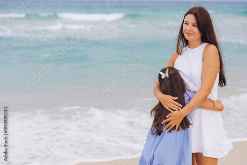 Photos Mother and daughter embracing on tropical beach, enjoying summer family vacation