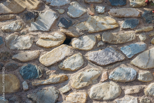 Rustic masonry stone wall texture creating a durable facade for traditional Mediterranean architecture and design in Sardinia