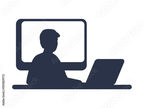 Silhouette of person working on laptop with large monitor screen behind them