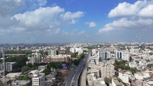 Vibrant cityscape with modern buildings and busy highway under blue sky