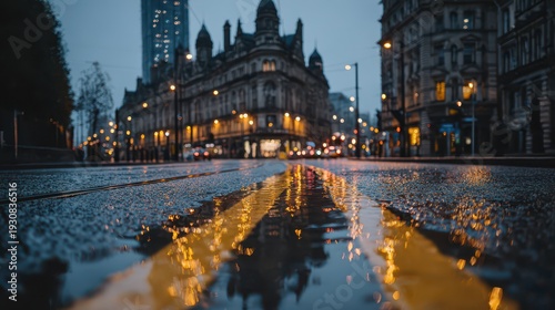 Low angle evening street scene with glowing reflections on rain-soaked boulevard