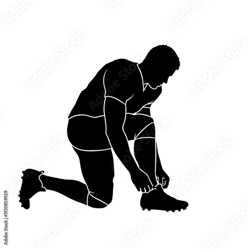 Silhouette of a person kneeling to tie a shoelace and prepare for activity.
