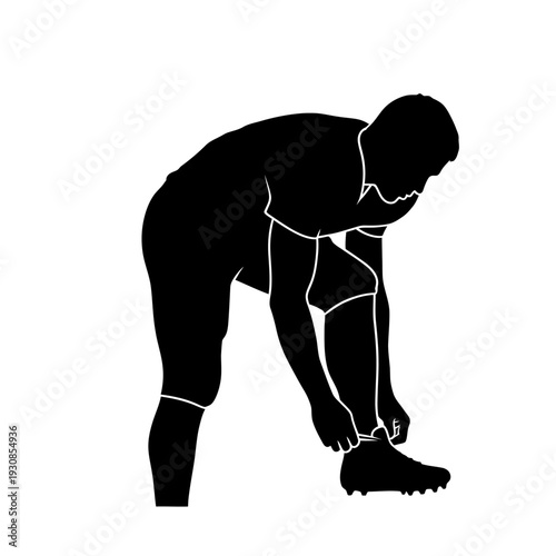 Silhouette of a person bending to tie a shoelace in a casual indoor scene.