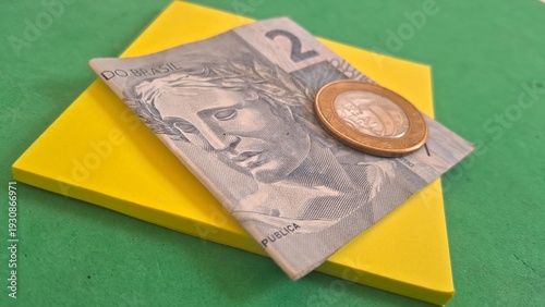 Obraz na plátně Brazilian currency note and coin on yellow background