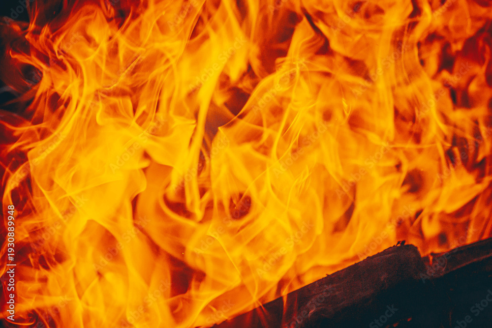 Fototapeta premium Bright fire flames close-up abstract burning background texture