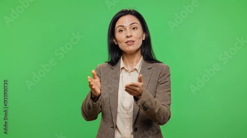 Professional Woman Demonstrating Hand Gestures in Front of Bright Green Backdrop
