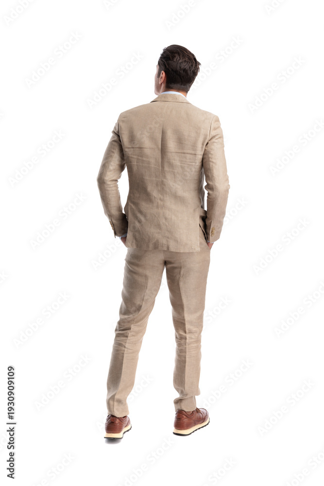 Naklejka premium Rear view of elegant man standing with hands in pockets