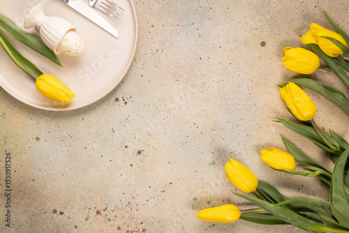 Easter egg on plate with yellow tulips