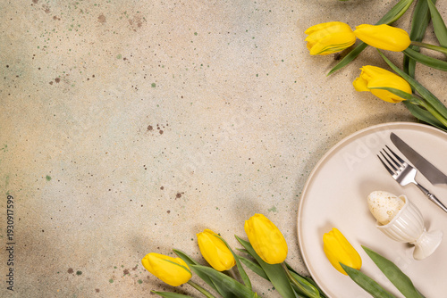 Easter table setting with yellow tulips and an egg
