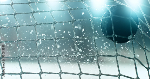 Photography Action sports photo of a hockey puck flying into the goal net during a scoring shot, with ice particles in the air, capturing speed and intensity