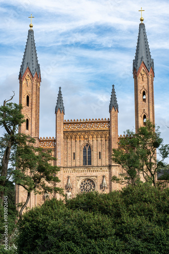 Portrait view of the Palace Church in Neustrelitz, partially hidden behind trees at the edge of the Palace Park, Mecklenburg-Western Pomerania, Germany.