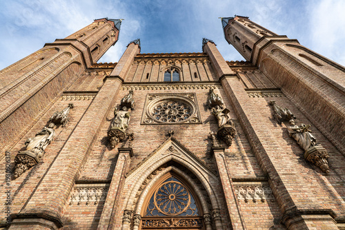 Steep angled view along the Palace Church facade in Neustrelitz at the edge of the Palace Park, Mecklenburg-Western Pomerania, Germany, featuring rosette windows and wall sculptures.